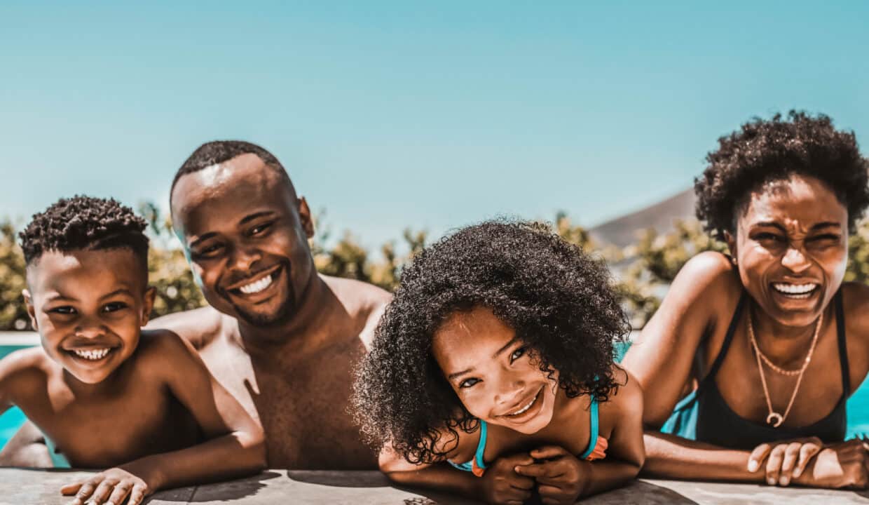 Happy,Young,Family,In,Swimming,Pool,On,A,Summer,Day.