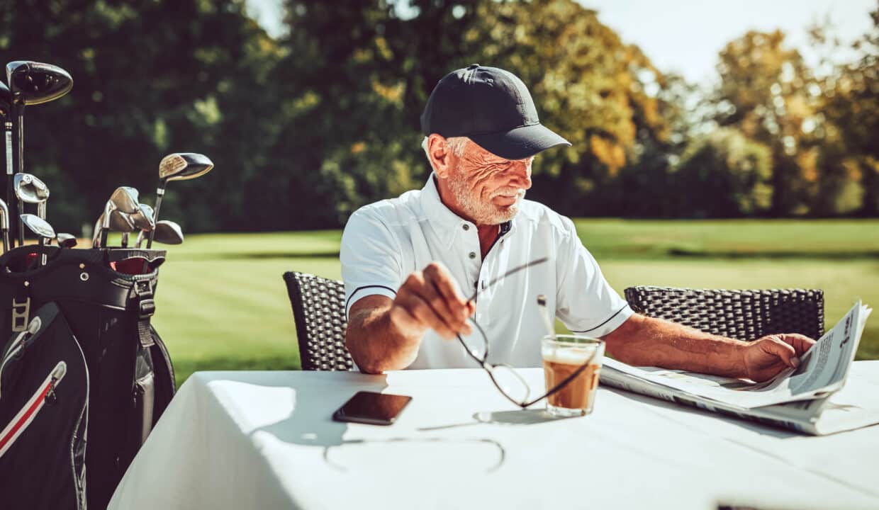Smiling,Senior,Man,Relaxing,At,His,Golf,Club,Restaurant,With